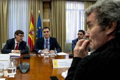 Pedro Sánchez, Salvador Illa (de izquierda a derecha) y Fernando Simón (en primer plano), durante una reunión en La Moncloa en marzo pasado.