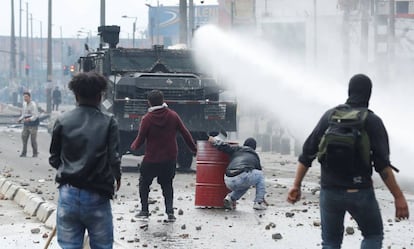 A polícia antidistúrbios em frente a um grupo de manifestantes nesta sexta-feira, em Bogotá.