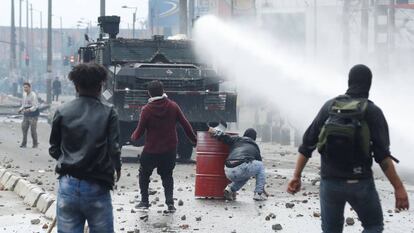 A polícia antidistúrbios em frente a um grupo de manifestantes nesta sexta-feira, em Bogotá.