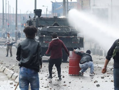 A polícia antidistúrbios em frente a um grupo de manifestantes nesta sexta-feira, em Bogotá.