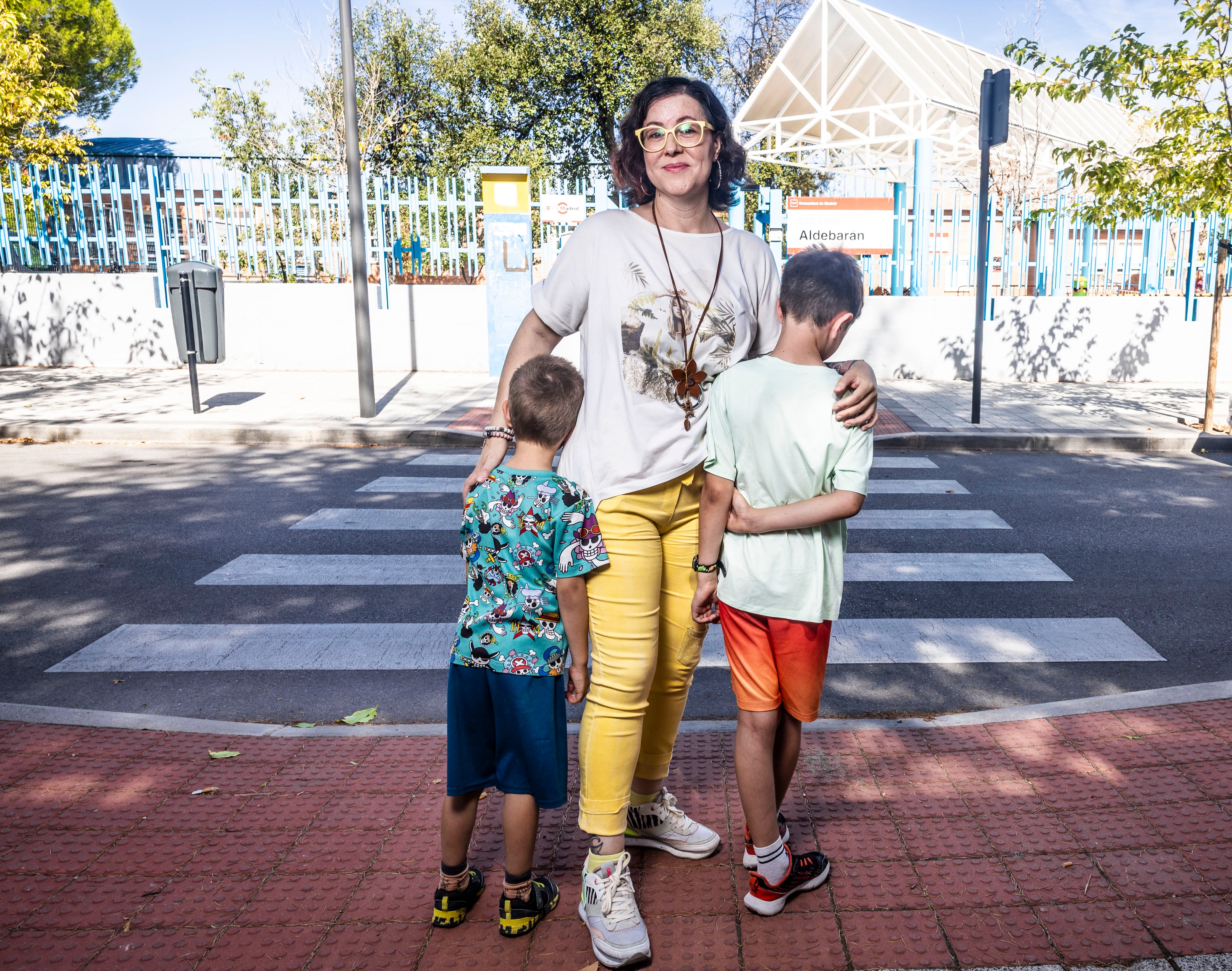 Ana Montero y sus dos hijos, delante del colegio público Aldebarán de Tres Cantos, Madrid.