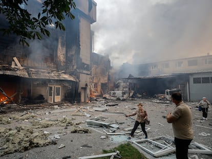 Varias personas junto a un edificio dañado tras un ataque ruso en Kiev, este martes.
