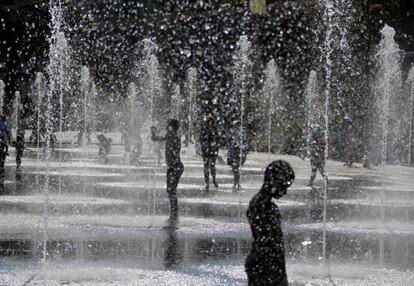 Niños se refrescan en unas fuentes de las calles de Niza, Francia.