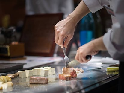 Un chef prepara carne de res al estilo teppanyaki.