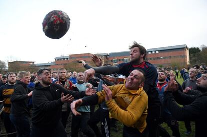 Dos juagdores luchan por la pelota durante el partido anual Royal Shrovetide Football Match, que combina fútbol y rugby, en Ashbourne (Reino Unido).
