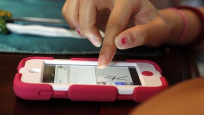 Una joven escribe un caracter chino en un teléfono móvil