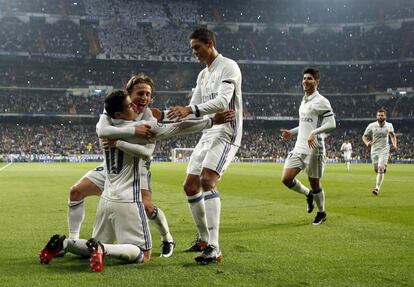 El delantero colombiano del Real Madrid James Rodríguez celebra con su compañeros, el centrocampista Luka Modric y el defensa francés Raphael Varane tras marcar su segundo gol, el tercero del equipo ante el Sevilla, en el partido de ida de octavos de final de la Copa del Rey, el 4 de enero de 2017.
