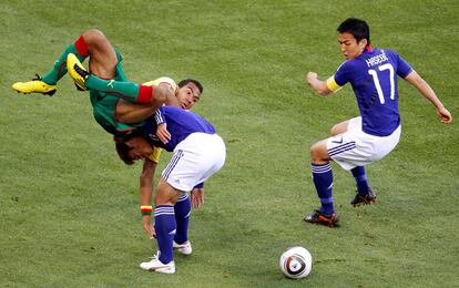 Yuichi Komano pelea por el balón con Eric Choupo-Moting ante la presencia de Makoto Hasebe.