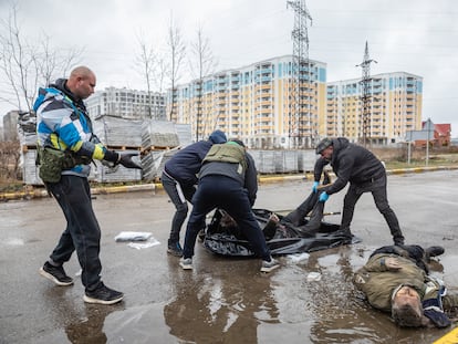 Unos voluntarios recogían unos cadáveres de la calle, el domingo en Bucha, cerca de Kiev.