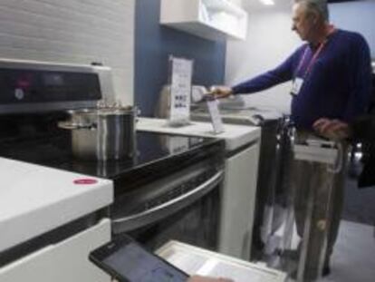 Asistentes a la feria CES comprueban cómo funcionan algunos electrodomésticos inteligentes presentados por LG