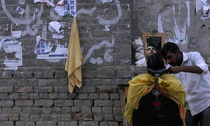 Un barbero paquistaní da los últimos retoques con la cuchilla a un cliente en un barrio cristiano de Islamabad, Pakistán.