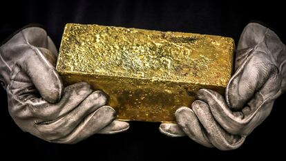 Una persona sostiene un lingote de oro de 20 kilos, en Australia.