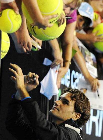 Roger Federer firma autógrafos tras ganar a Hartfield.