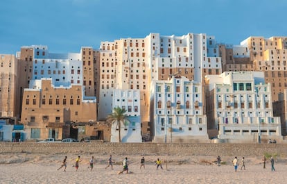 Jóvenes juegan en la arena ante varios edificios de la ciudad de Shibam, al oeste de la gobernación yemení de Hadramaut.