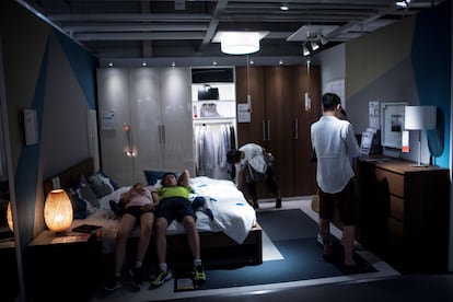 Dos jóvenes se tumban en la cama de uno de los apartamentos de exhibición en un Ikea de Shanghái.
