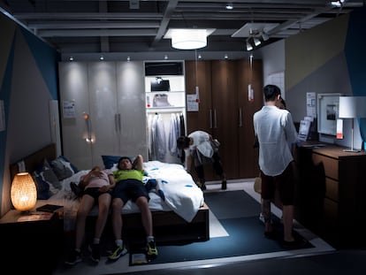 Dos jóvenes se tumban en la cama de uno de los apartamentos de exhibición en un Ikea de Shanghái.