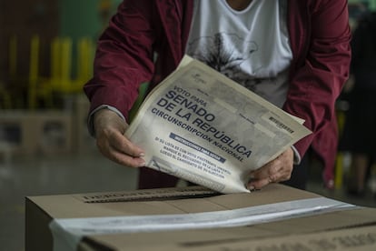 Una mujer deposita su voto en un colegio electoral en Bogotá, Colombia.