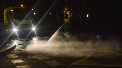 Un trabajador del Ayuntamiento de Madrid limpia con una manguera a presión la calle Plaza de la Marina frente al Senado, el 18 de julio.
