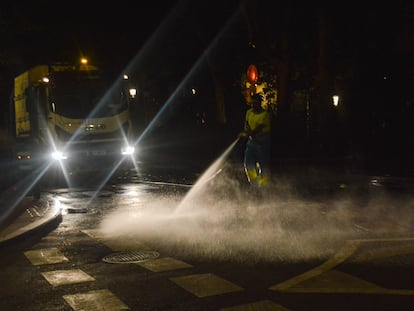 Un trabajador del Ayuntamiento de Madrid limpia con una manguera a presión la calle Plaza de la Marina frente al Senado, el 18 de julio.