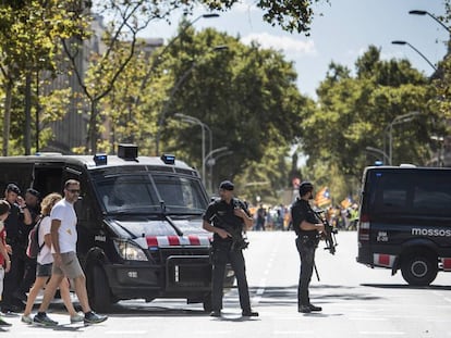 Un parell de furgons dels Mossos vigilen a la Gran Via la manifestació a Barcelona.