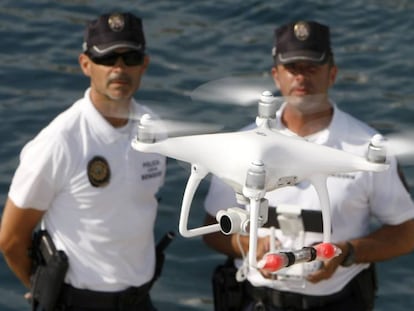 Agentes da polícia local de Benidorm e o drone usado para monitorar o litoral.