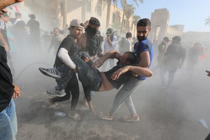 En la imagen, partidarios de al Sadr ayudan a los manifestantes heridos durante los enfrentamientos con las fuerzas antidisturbios cerca de la oficina del primer ministro, Bagdad, el lunes.