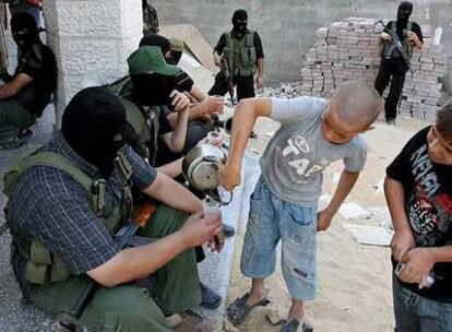 Un niño sirve té a militantes de Hamás durante los enfrentamientos armados registrados ayer en la ciudad de Gaza.