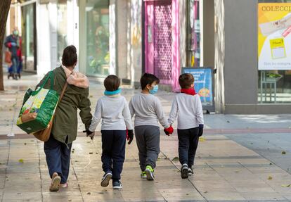 Una madre y sus hijos tras hacer la compra en Zaragoza.