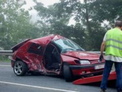 Un coche accidentado es recogido por la gr&uacute;a.