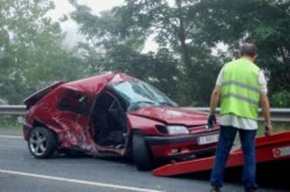 Un coche accidentado es recogido por la gr&uacute;a.