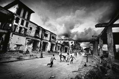 Niños somalíes juegan al fútbol en la calle entre edificios en ruinas (Mogadiscio, Somalia, 28 de marzo de 2007).