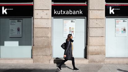 Una mujer camina por delante de una sucursal de Kutxabank, en Salamanca.