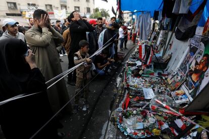 Un grupo de personas ante un monumento improvisado creado con pertenencias personales de los que fueron asesinados en una protesta contra el Gobierno en la plaza Tahrir en Bagdad, el 27 de noviembre de 2019.