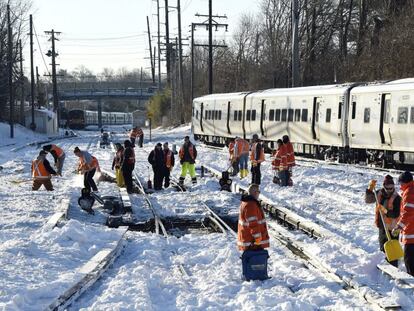 Trabajadores limpian las vías en un tramo de Long Island, en Nueva York.