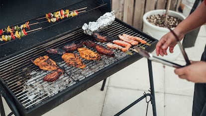 Een persoon die voedsel op een barbecue bereidt