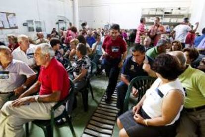 Amador Pacheco (c), portavoz de la plataforma de afectados por las particiapaciones preferentes de O Salnés, durante la reunión de afectados en la lonja de O Grove (Pontevedra) para informar a las distintas plataformas y decidir las acciones que llevarán a cabo para publicitar su causa.