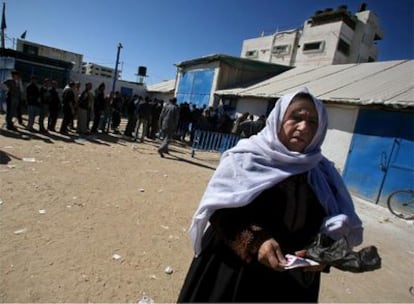Una mujer palestina muestra su cupón para recibir comida en un centro de reparto de ayuda humanitaria de la UNRWA en Gaza.