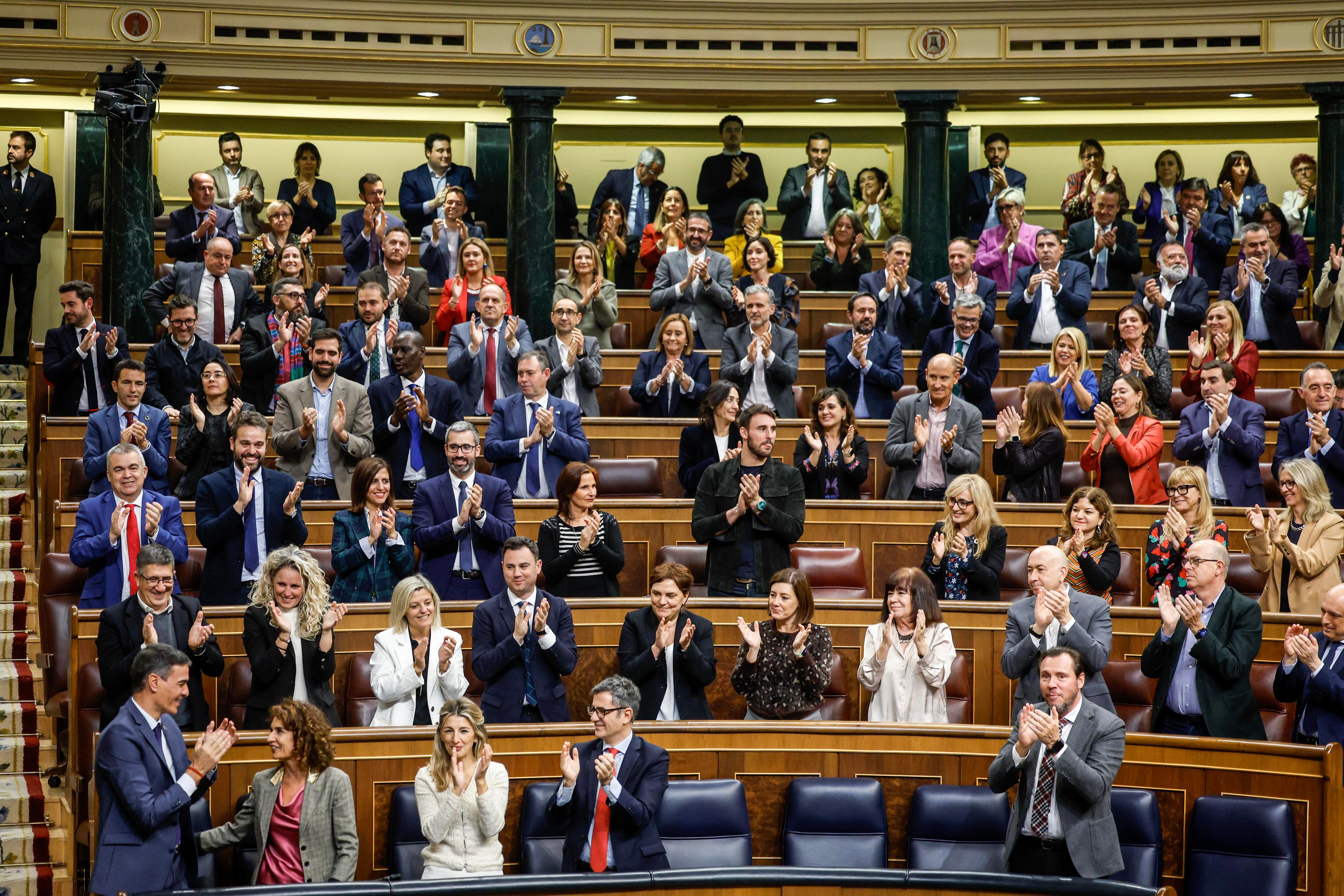 El presidente del Gobierno, Pedro Sánchez (abajo izquierda), las vicepresidentas María Jesús Montero y Yolanda Díaz y los ministros de Presidencia, Félix Bolaños, y de Transportes, Óscar Puente, aplauden tras la aprobación de la reforma fiscal, este jueves en el Congreso.