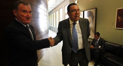 Juan Ramón Avilés y José Enrique Garrigós (derecha) se saludan tras comparecer en las Cortes.