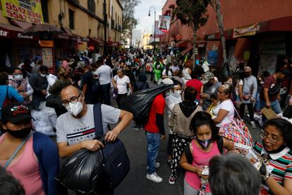 Vendedores y transeúntes se aglomeran en una calle del Centro Histórico de Ciudad de México ayer a pocos días de celebrar el Día de la Candelaria en semáforo rojo.