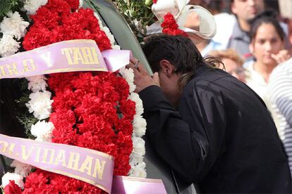 Un joven observa a través del cristal del coche fúnebre el féretro de uno de los cuatro fallecidos a causa del tiroteo.