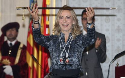 Sonia Castedo (PP), imputada en el 'caso Brugal', muestra la vara de mando en el Ayuntamiento de Alicante. Dos concejales de Esquerra Unida han abandonado el pleno durante su juramento y se han unido a un grupo de personas del Movimiento 15-M que se manifestaban a las puertas.