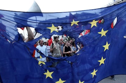 Manifestantes antigubernamentales queman una bandera europea en Sal&oacute;nica.