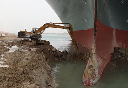 Una excavadora retira tierra junto al buque, este jueves. El canal de Suez es la principal vía del comercio entre Asia y Europa, aunque las rutas más transitadas son las que pasan por el estrecho de Malaca, centro del comercio intrasiático, y por el canal de la Mancha, por donde cada día transitan 400 buques, aunque de menores dimensiones.