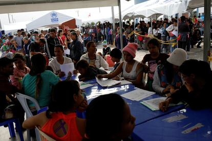 El informe estima que los venezolanos salen de su país a un ritmo de 5.000 personas al día y que, de continuar así, llegarán a los cinco millones en el extranjero a finales de 2019. En la imagen, migrantes venezolanos hacen filas para procesar sus documentos en el centro de servicio fronterizo peruano-ecuatoriano en Tumbes (Perú).