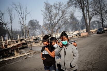 Sandra, Daniela y Ester Reyes recorren las calles después de que los incendios forestales destruyeran el vecindario donde vivían en Bear Creek, Phoenix, Oregón.