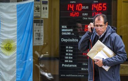 Un argentino pasa por delante de una pizarra con la cotizaci&oacute;n del d&oacute;lar en Buenos Aires.