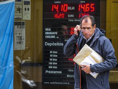 Un argentino pasa por delante de una pizarra con la cotizaci&oacute;n del d&oacute;lar en Buenos Aires.