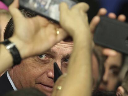 O presidente Jair Bolsonaro tira fotos com seus apoiadores em Brasília, no dia 21 de maio.