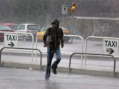 Un hombre corriendo bajo la lluvia ayer por la mañana en los alrededores de la etsación de Renfe de Sants.